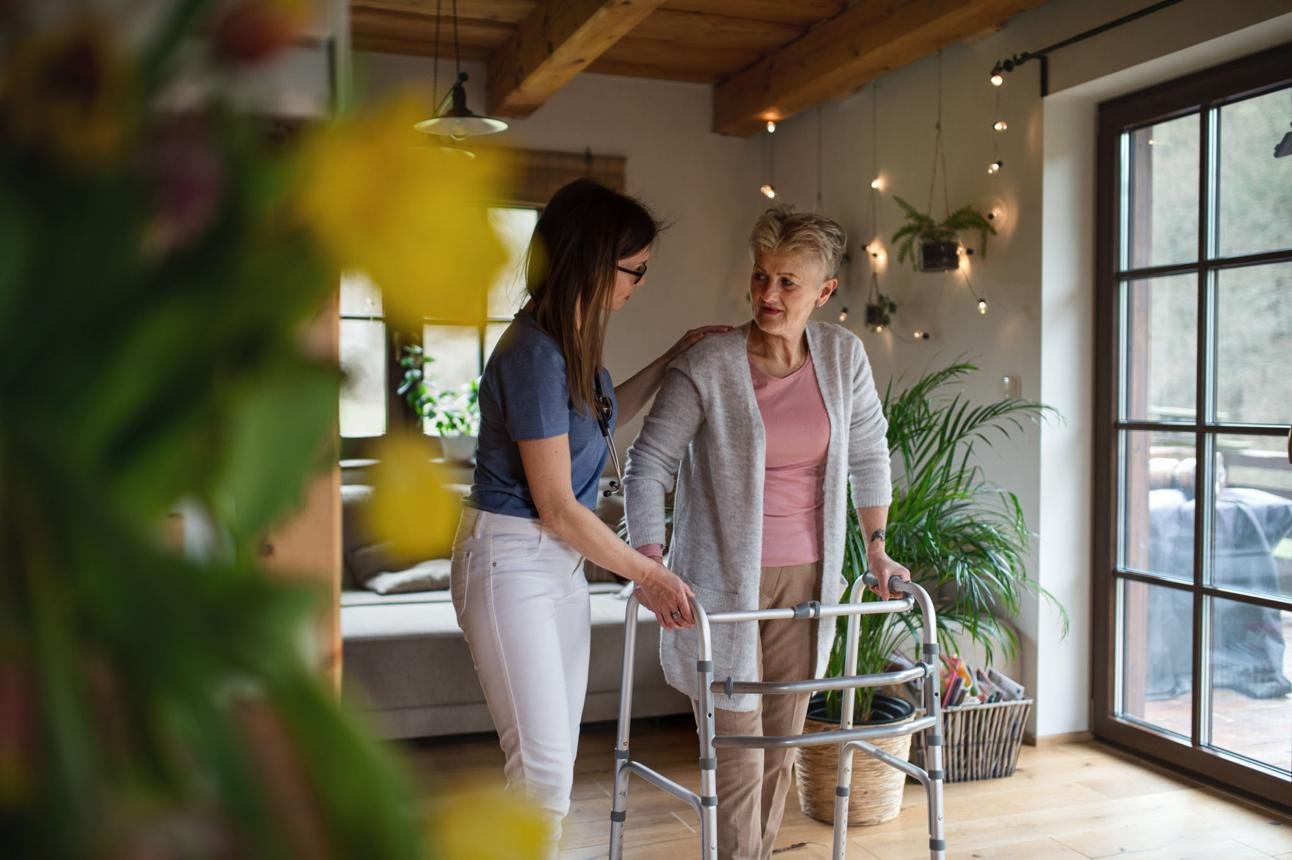 Caregiver assisting senior client with walking support
